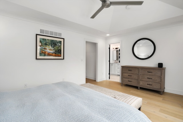 unfurnished bedroom featuring light hardwood / wood-style flooring, ensuite bathroom, ceiling fan, and vaulted ceiling