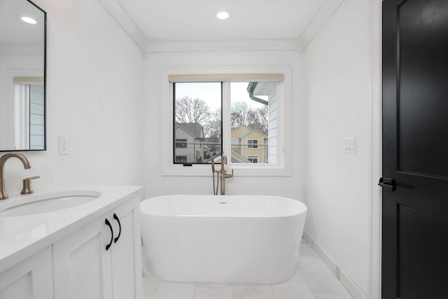 bathroom with crown molding, vanity, and a bath