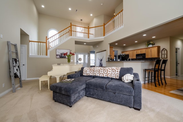 living room featuring a towering ceiling and light carpet