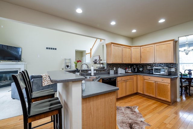 kitchen with sink, backsplash, a notable chandelier, and kitchen peninsula