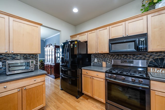 kitchen with light brown cabinets, decorative backsplash, light wood-type flooring, and black appliances