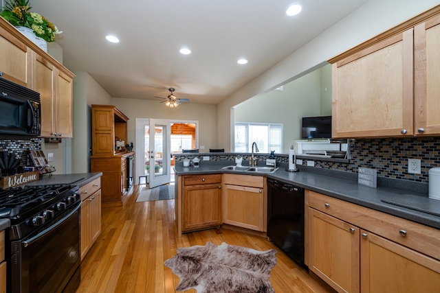 kitchen with light hardwood / wood-style flooring, sink, kitchen peninsula, and black appliances