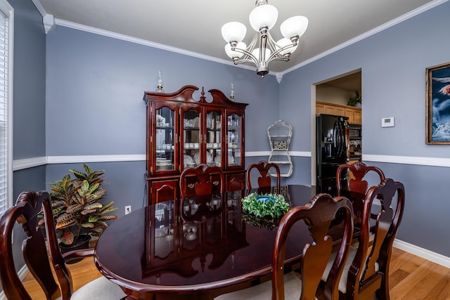 dining area with crown molding, a chandelier, and light hardwood / wood-style floors