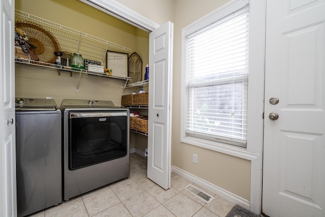 laundry area with light tile patterned flooring and separate washer and dryer