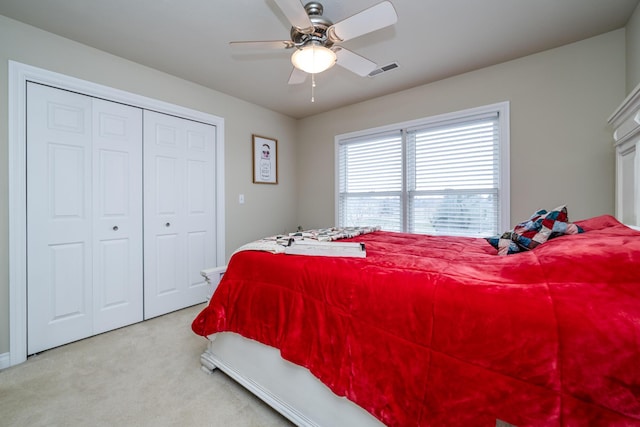 carpeted bedroom featuring ceiling fan and a closet