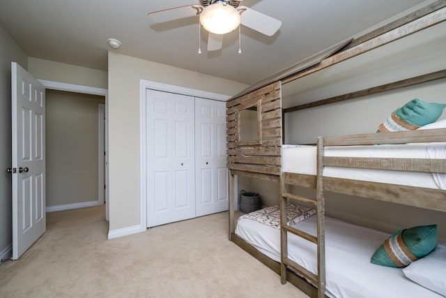 carpeted bedroom featuring ceiling fan and a closet