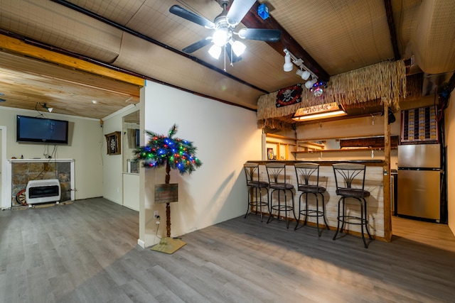 bar with heating unit, hardwood / wood-style floors, a fireplace, stainless steel fridge, and wooden ceiling