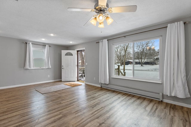 entryway featuring hardwood / wood-style floors, a baseboard radiator, a textured ceiling, and ceiling fan