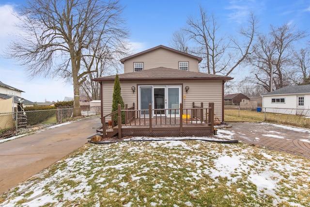 snow covered rear of property with a wooden deck