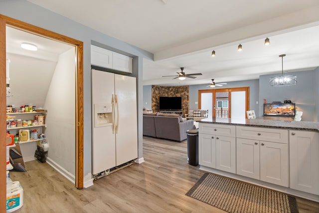 kitchen with light hardwood / wood-style flooring, pendant lighting, dark stone counters, white refrigerator with ice dispenser, and white cabinets