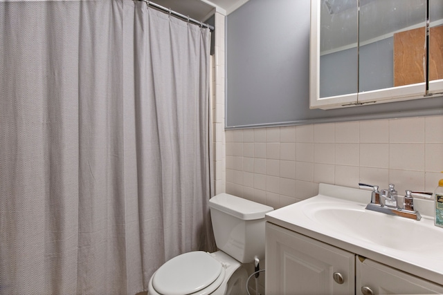 bathroom featuring vanity, tile walls, and toilet