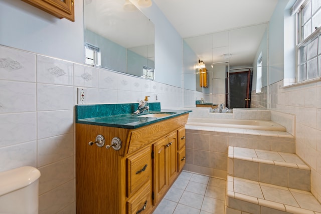 bathroom with tile patterned flooring, a healthy amount of sunlight, and tile walls