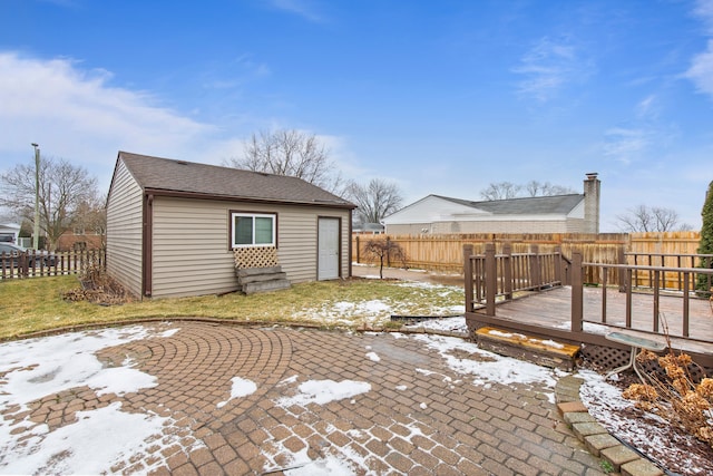 snow covered patio with a wooden deck