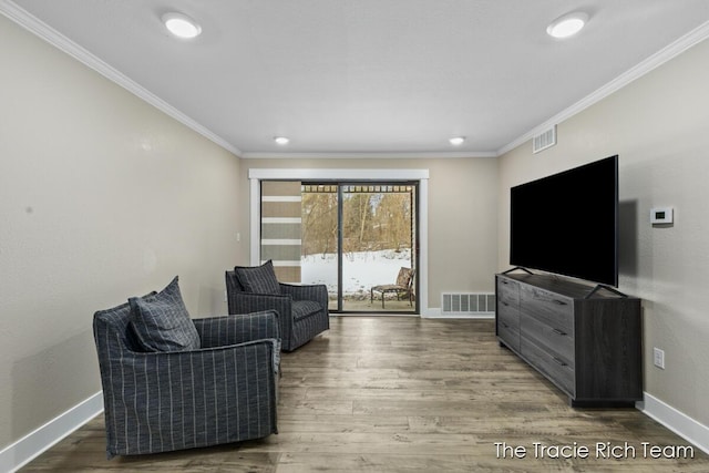 living room with wood-type flooring and ornamental molding