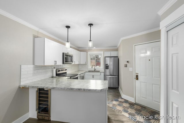 kitchen featuring white cabinetry, sink, stainless steel appliances, and kitchen peninsula