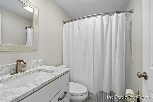 bathroom featuring vanity, curtained shower, and toilet