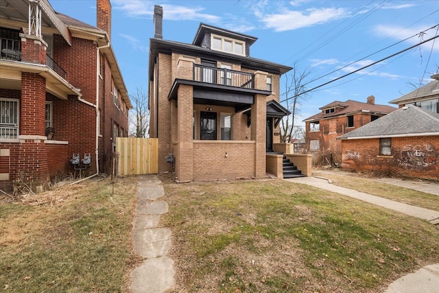 view of front of home featuring a balcony and a front lawn