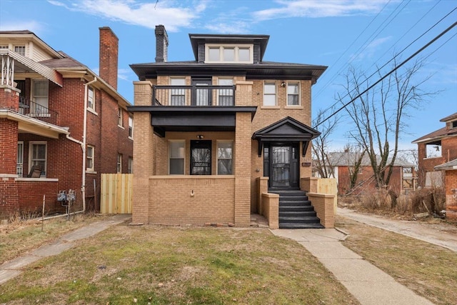 view of front of home with a balcony and a front yard