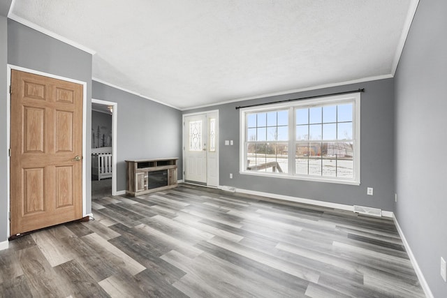 unfurnished living room with hardwood / wood-style flooring, crown molding, and a textured ceiling