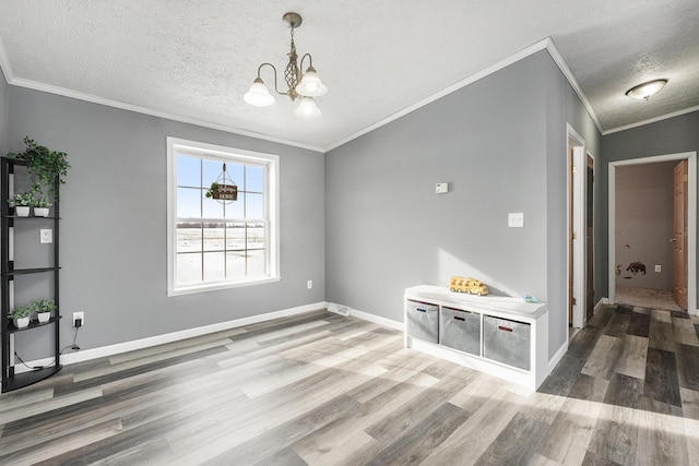 interior space with hardwood / wood-style floors, crown molding, a chandelier, and a textured ceiling