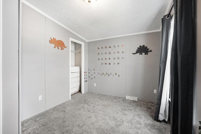 unfurnished bedroom with carpet floors, ornamental molding, and a textured ceiling