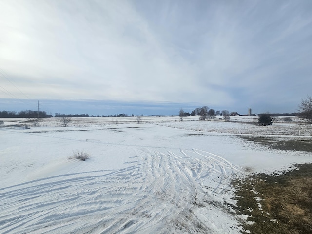 snowy yard with a rural view