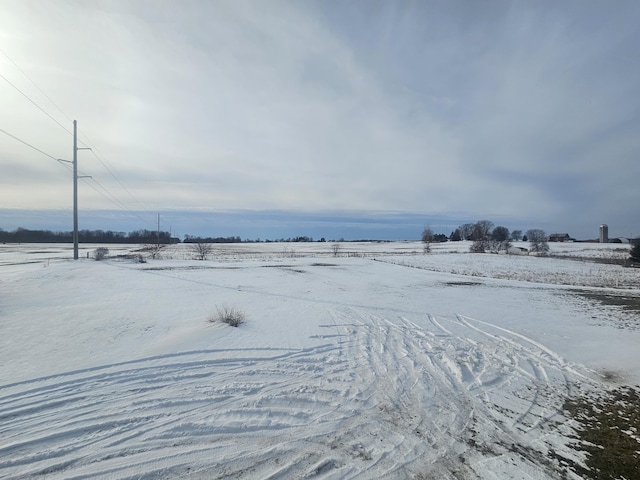 yard covered in snow featuring a rural view