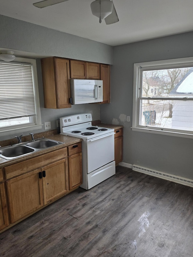 kitchen with dark wood-type flooring, sink, baseboard heating, ceiling fan, and white appliances