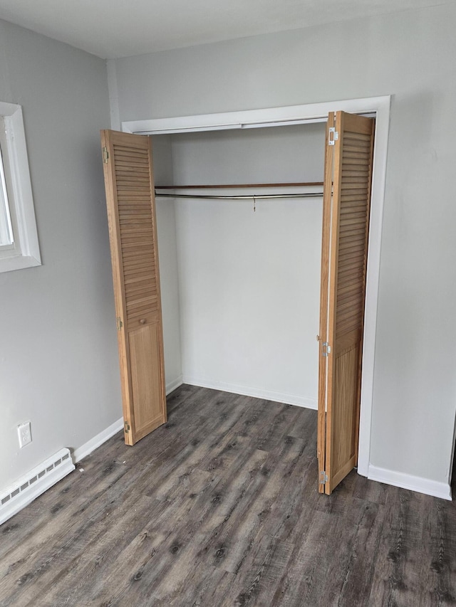 interior space featuring a baseboard heating unit, dark hardwood / wood-style floors, and a closet