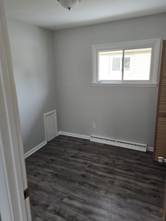 empty room featuring dark hardwood / wood-style floors and baseboard heating