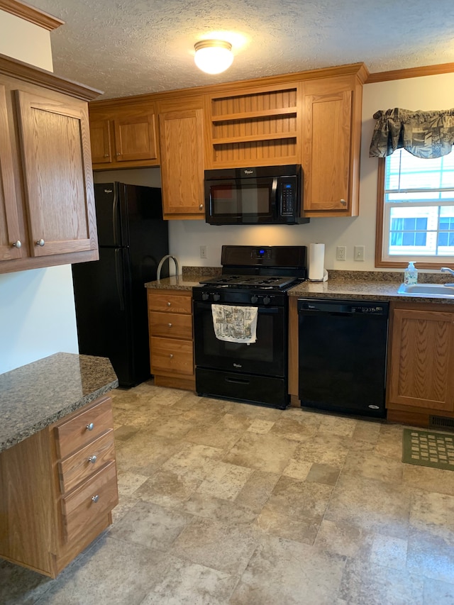 kitchen featuring sink, dark stone counters, ornamental molding, black appliances, and a textured ceiling