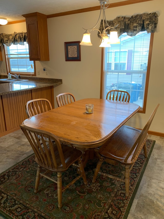 dining space with ornamental molding, sink, and a notable chandelier