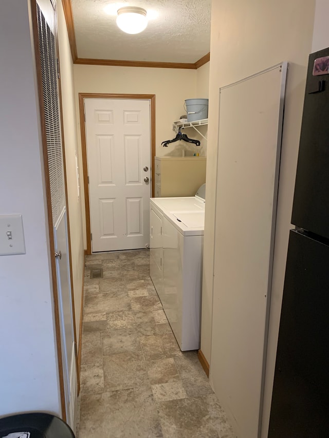 laundry room featuring washer and clothes dryer, ornamental molding, and a textured ceiling