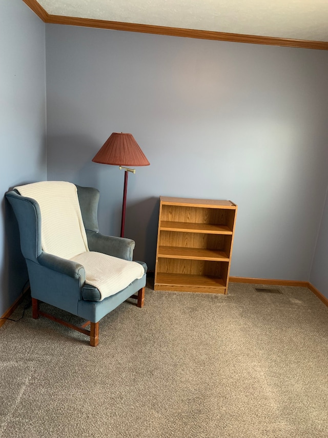 sitting room with crown molding and carpet