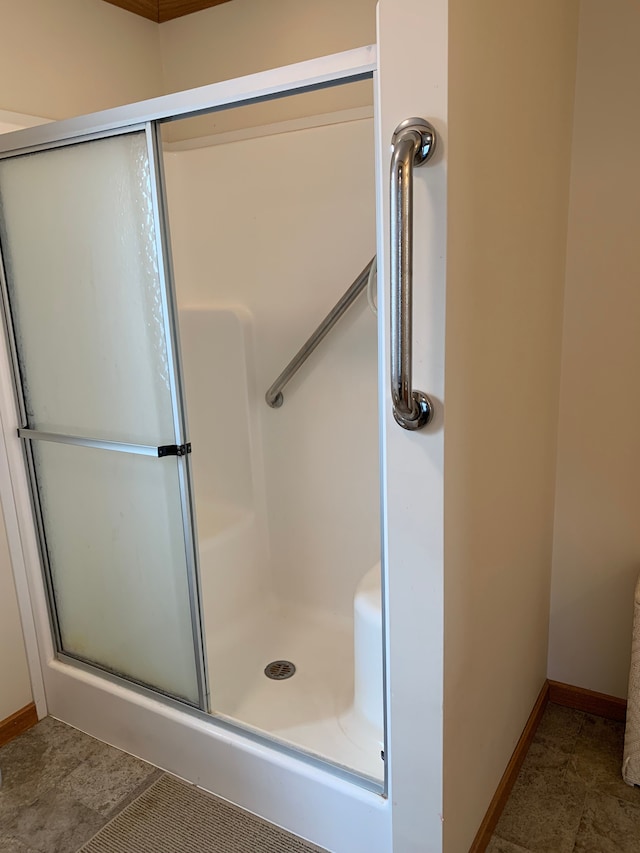 bathroom with tile patterned floors and a shower with door