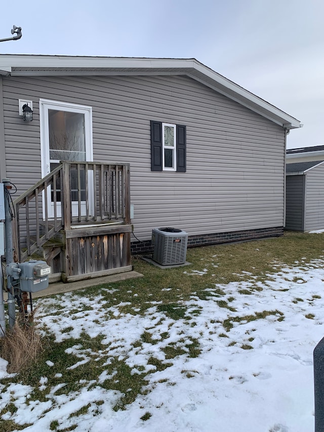 snow covered property with cooling unit