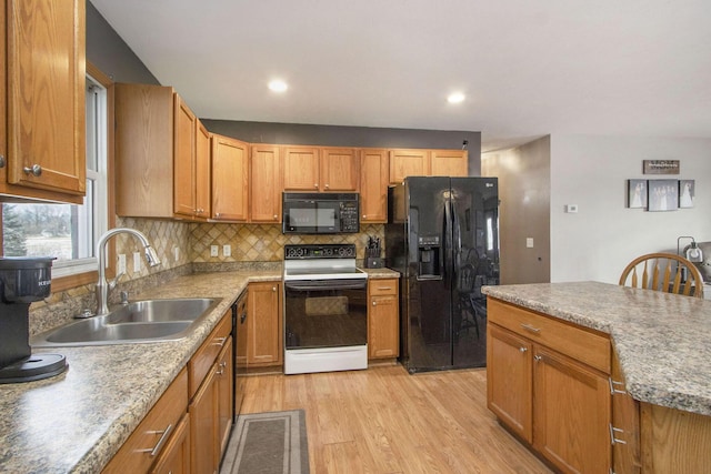 kitchen with tasteful backsplash, sink, light hardwood / wood-style flooring, and black appliances