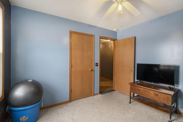 interior space with light carpet and ceiling fan