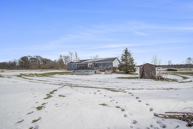 snow covered property with a storage unit