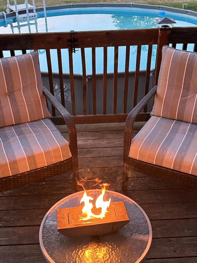 wooden balcony featuring a wooden deck and an outdoor fire pit