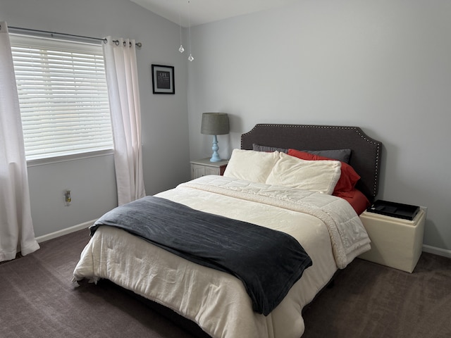 bedroom featuring lofted ceiling and dark colored carpet