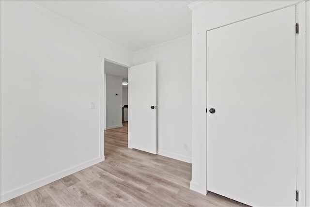 interior space featuring crown molding and light hardwood / wood-style flooring