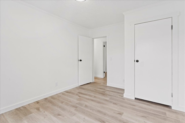 unfurnished bedroom with ornamental molding and light hardwood / wood-style floors