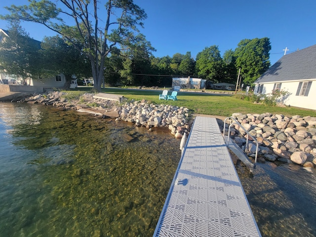 dock area featuring a water view and a lawn