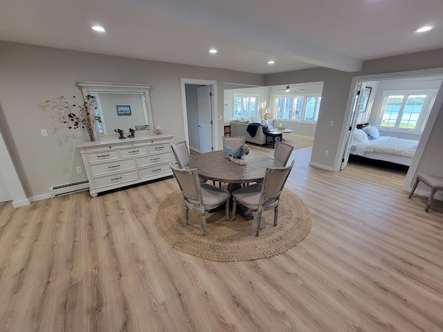 dining space featuring a baseboard heating unit and light wood-type flooring