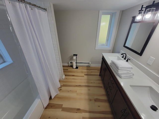 bathroom featuring vanity, a baseboard heating unit, hardwood / wood-style flooring, and shower / tub combo with curtain