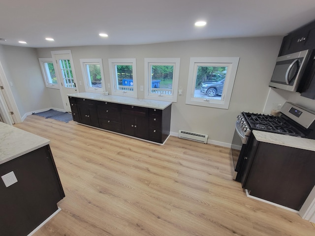 kitchen featuring stainless steel appliances, light wood-type flooring, and a baseboard heating unit