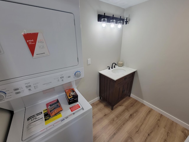 bathroom with vanity, hardwood / wood-style floors, and stacked washing maching and dryer