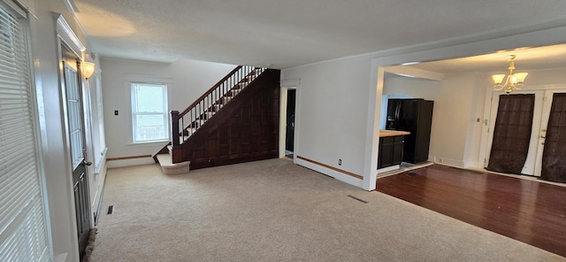 entryway with carpet and an inviting chandelier