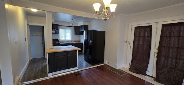 kitchen with crown molding, dark wood-type flooring, wood counters, and black appliances